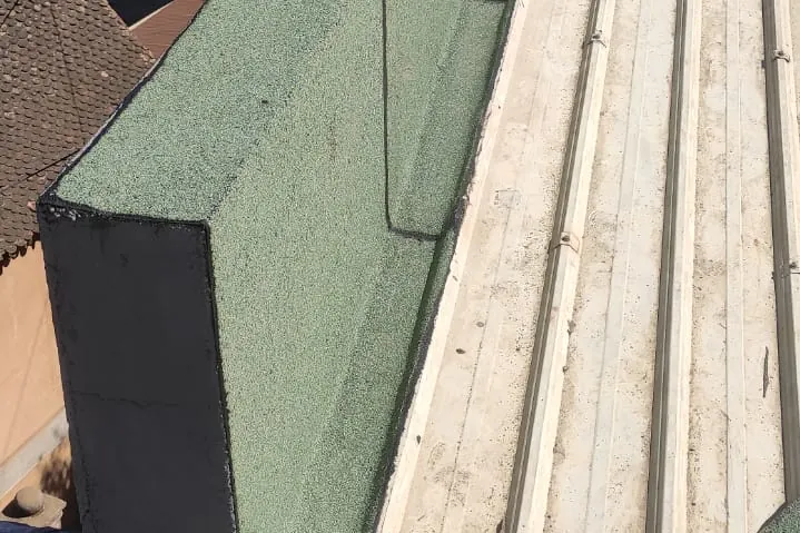 Acrotère recouvert d’une membrane ardoisée verte.
