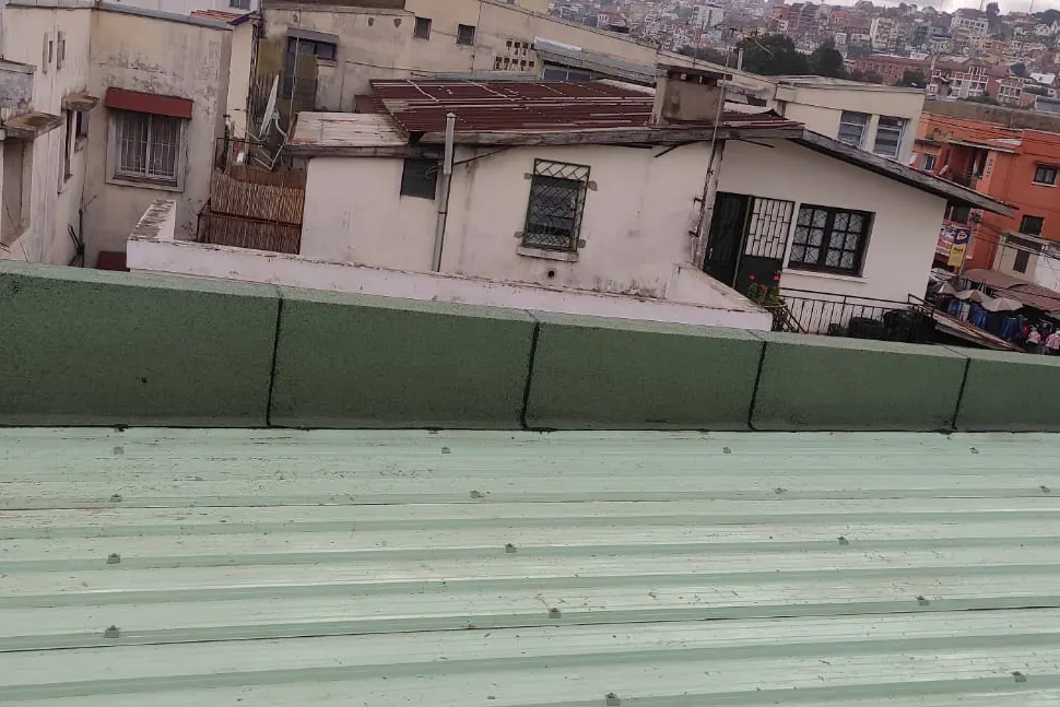 Rive de toiture protégée par une membrane d’étanchéité verte.