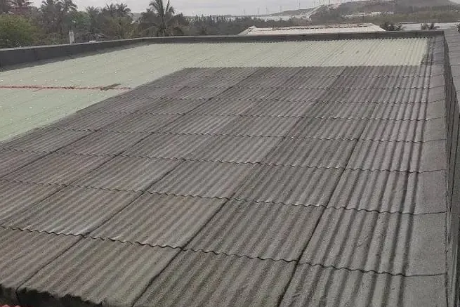 Toiture en tôle ondulée d’un bâtiment protégée par une membrane d’étanchéité.